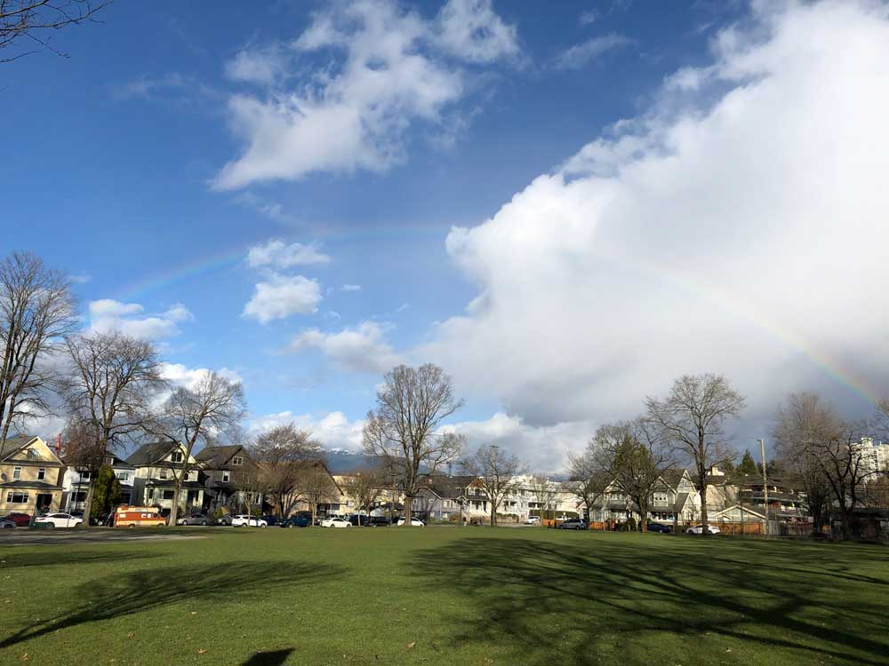 Image of a rainbow over a park.