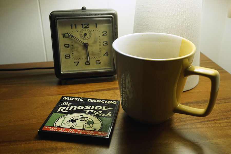 photo of coffee cup next to an old clock.