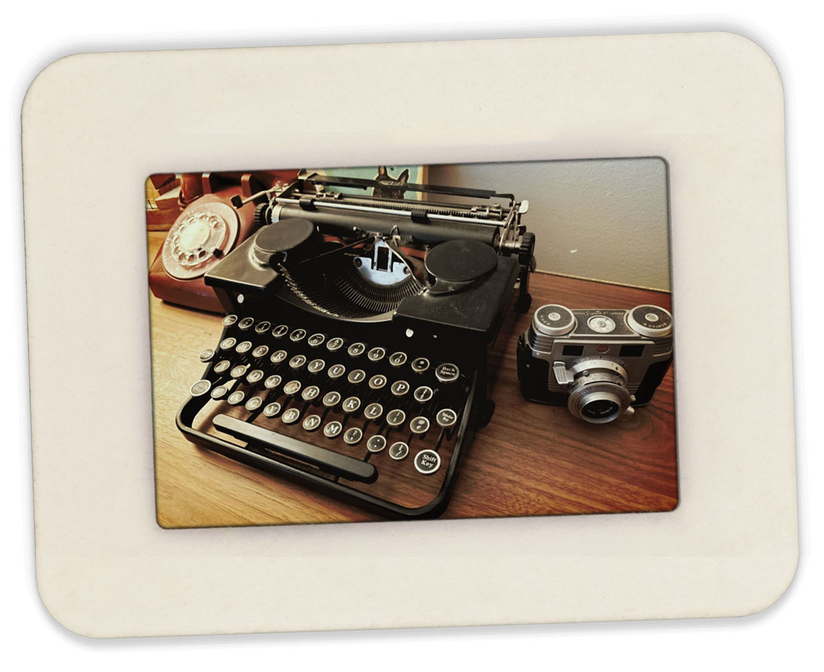 Image of a vintage typewriter, camera, and old rotary telephone.